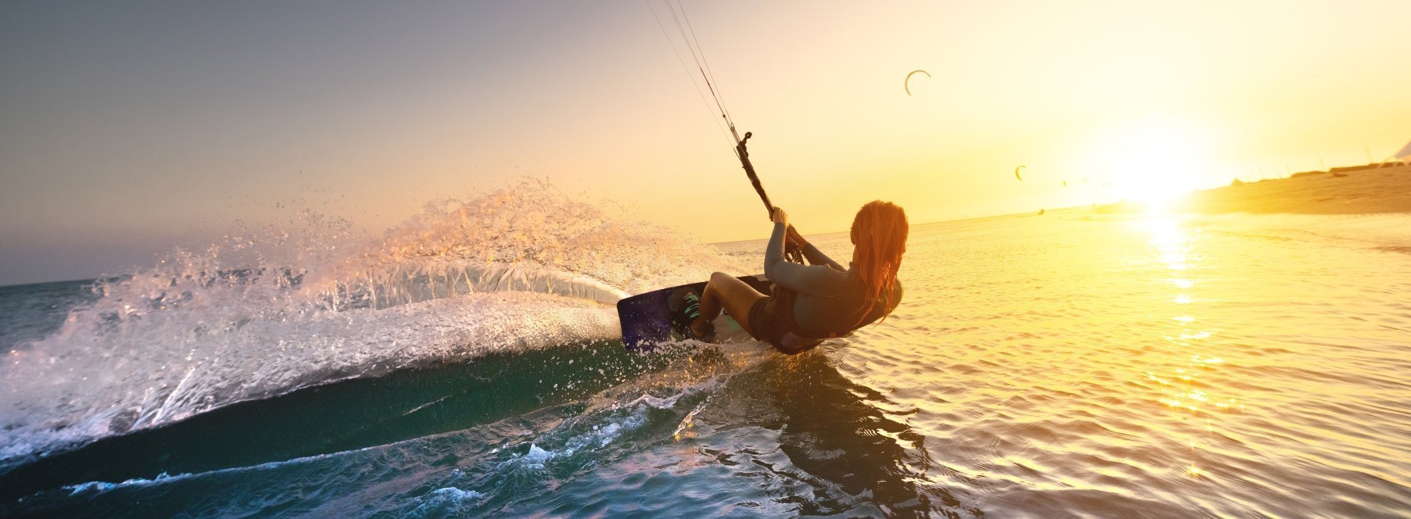 Kitesurfer beim Wassersport im Fünfseenland – Kite- und Wingsurfen auf dem See bei Sonnenuntergang